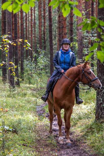 Woman horseback riding in the forest