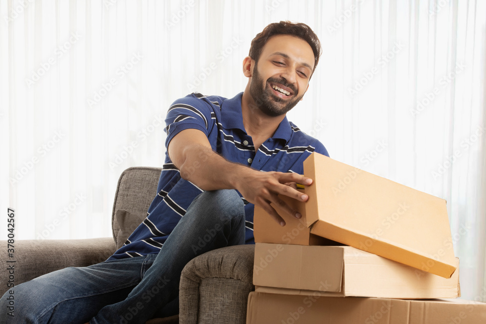 Man unboxing his new shoes happily Man unboxing his new shoes happily