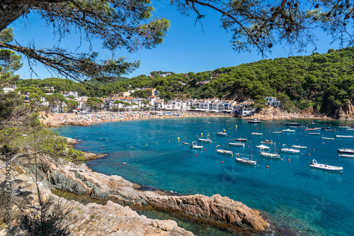 Views of beach and town of Tamariu with lot of people.