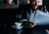 business man sitting at a table in a cafe documents work official coffee cup 