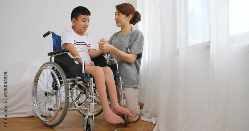 A physical therapist is talking to a disabled boy in a wheelchair. A physical therapist is talking to a disabled boy in a wheelchair.