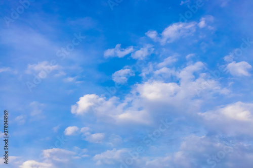 Abstract atmospheric background. Delicate clouds in the blue sky. The sun illuminates the clouds from the side.