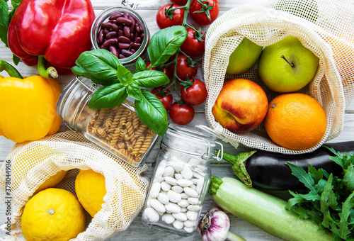 Fototapeta Naklejka Na Ścianę i Meble -  Fresh fruits and vegetables in eco cotton bags on table in the kitchen.