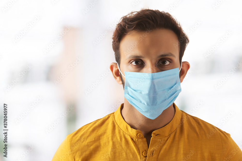 Portrait of a young man taking precautions by wearing a mask Portrait of a young man taking precautions by wearing a mask