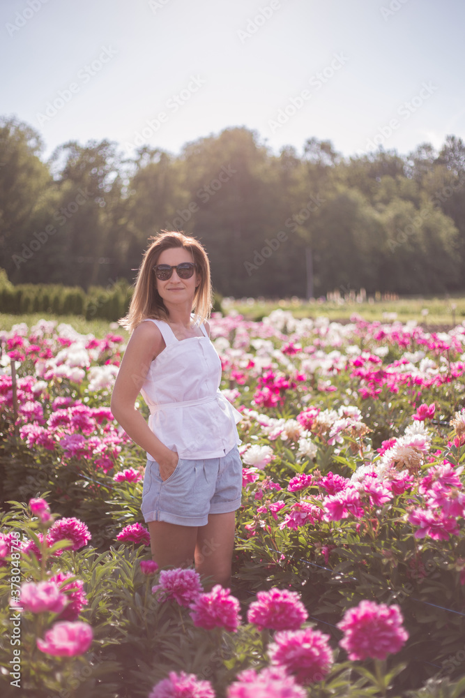 Young woman walking in blooming field. Young woman walking in blooming field.