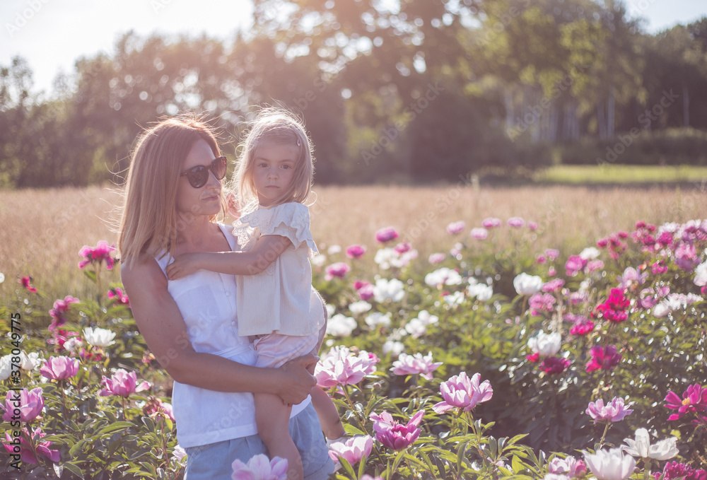 Mother and little girl walking in field of flowers Mother and little girl walking in field of flowers