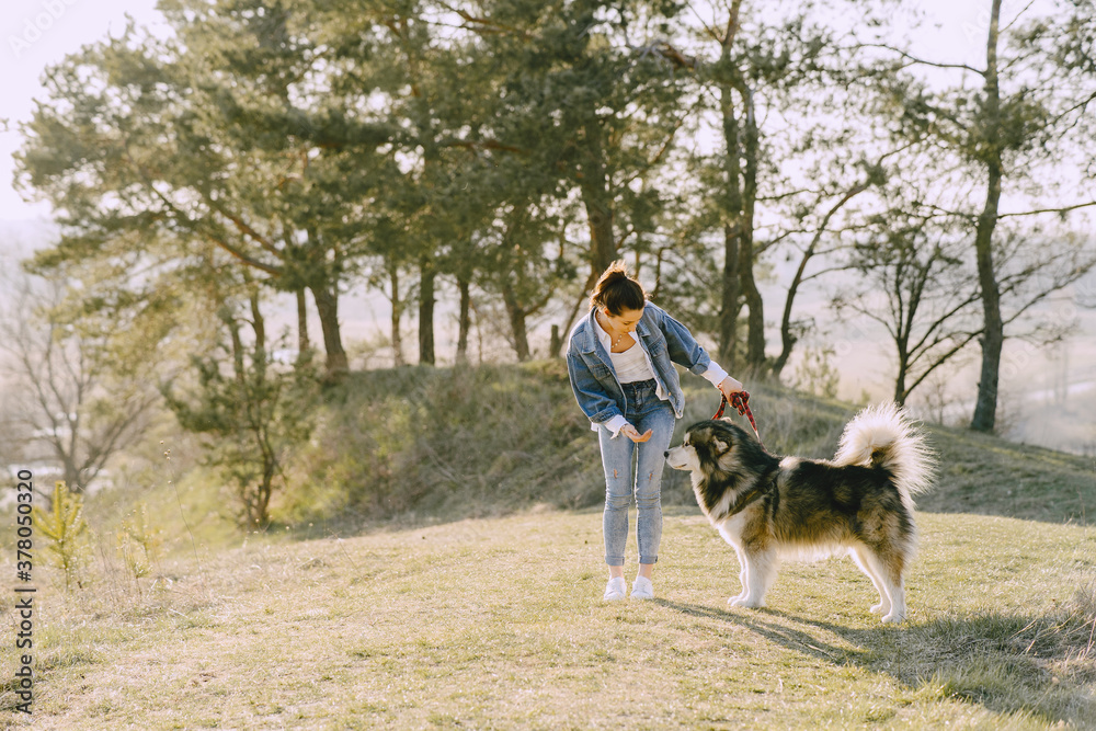 Woman in a spring forest. Girl with cute dog. Brunette in a jeans jacket. Woman in a spring forest. Girl with cute dog. Brunette in a jeans jacket.
