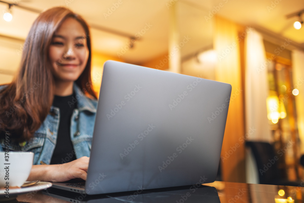 Closeup image of a young woman working on laptop computer on the table