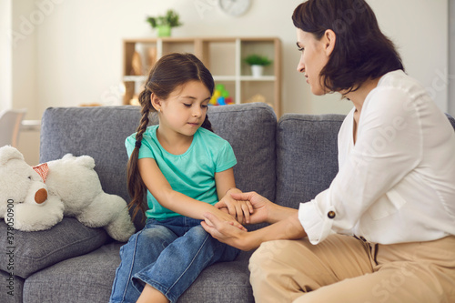 Картината върху платно Mother sitting with daughter, holding her hands, talking to her and teaching her