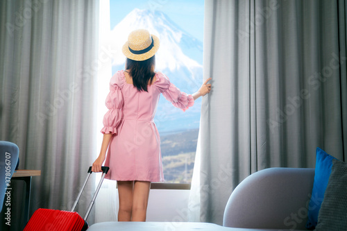 Photography Asian woman traveller arrive to room in hotel and open curtain for enjoy fuji vi