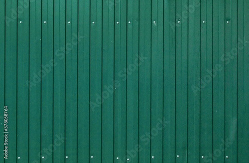 Background of painted corrugated tin iron with galvanized screw heads and vertical orientation