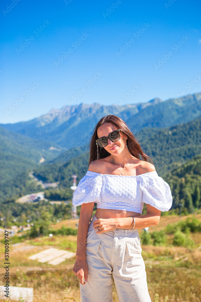 Naklejka premium Beautiful happy young woman in mountains in the background of fog