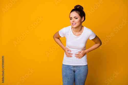 Frustrated stressed girl hipster have health care problem suffer abdominal menstruation pain touch her belly hands cry wear white t-shirt denim jeans isolated bright shine color background