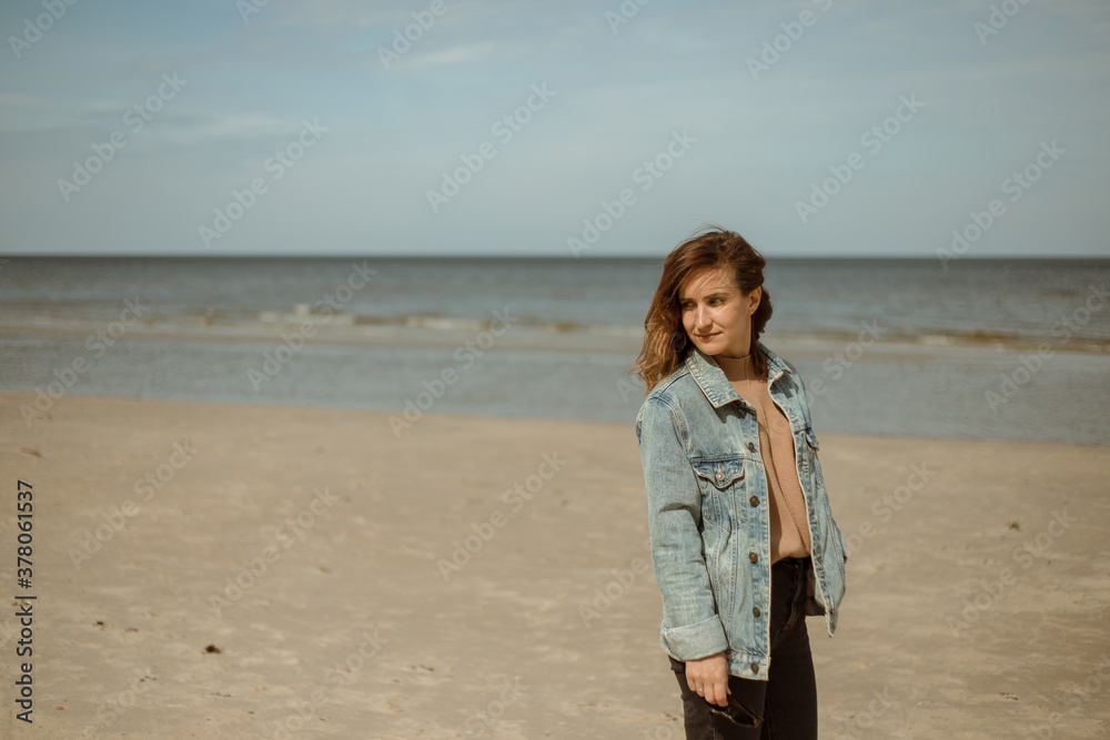 Great pleasure. Charming calm young woman is standing near sea.Attractive woman in jeans with brunette hair.Denim beauty. Great pleasure. Charming calm young woman is standing near sea.Attractive woman in jeans with brunette hair.Denim beauty.