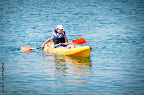 kayaking lessons. Boy with life buoy suit in kayak lessons during summer vacations in an island of Greece.