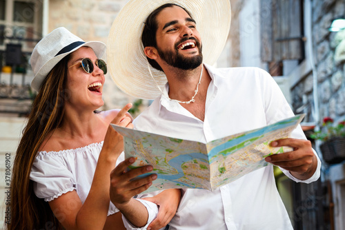 Happy tourists couple in love sightseeing city with map during summer vacation