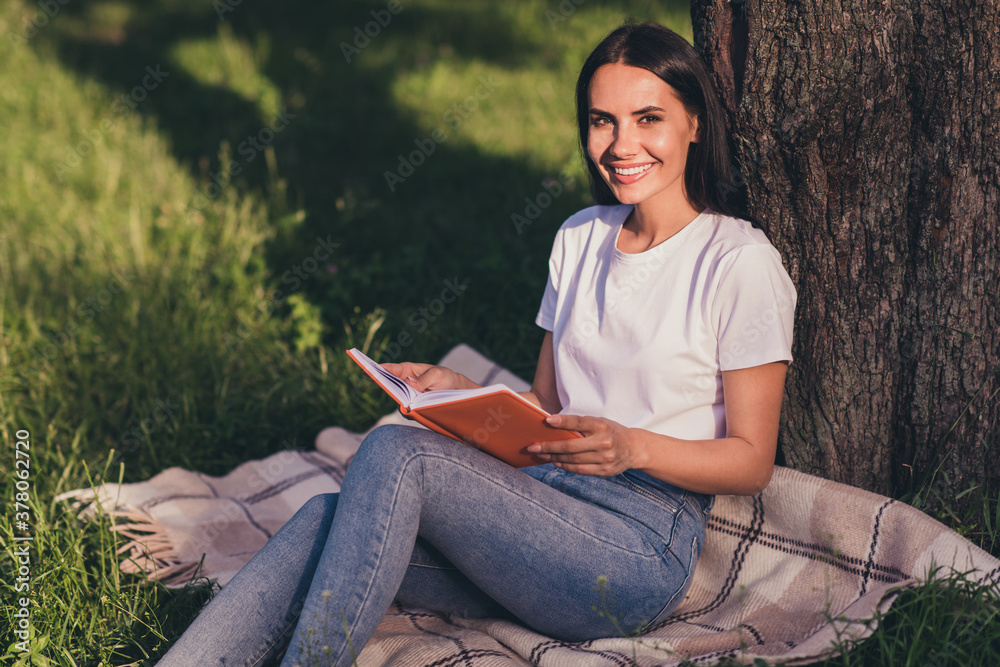 Portrait of her she nice attractive pretty lovely cheerful cheery smart clever girl reading book diary sitting on lawn green color grass veil duvet planning week month business