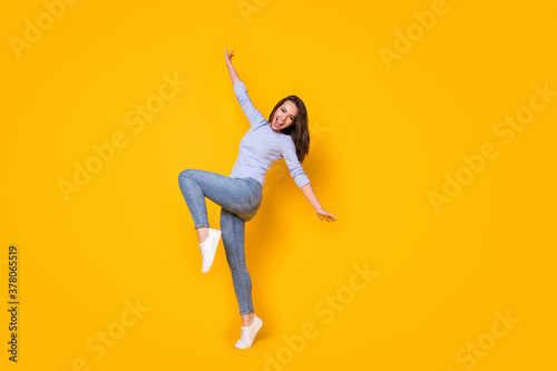 Full length body size view of her she attractive cheerful cheery girl jumping having fun chill out rest relax party time active life dance isolated bright vivid shine vibrant yellow color background