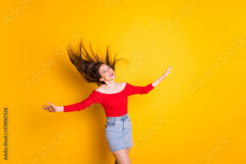 Portrait of her she nice-looking attractive lovely pretty dreamy glad cheerful cheery girl throwing hair having fun enjoying isolated over bright vivid shine vibrant yellow color background