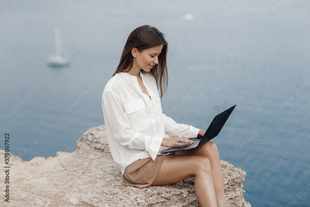 Young happy business woman with laptop outdoor