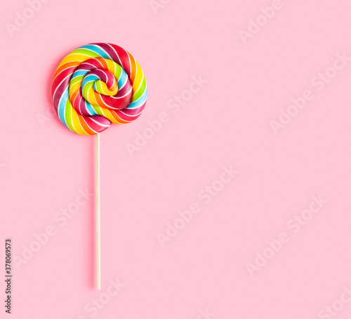Wallpaper Mural Rainbow colored lollipop on pink background