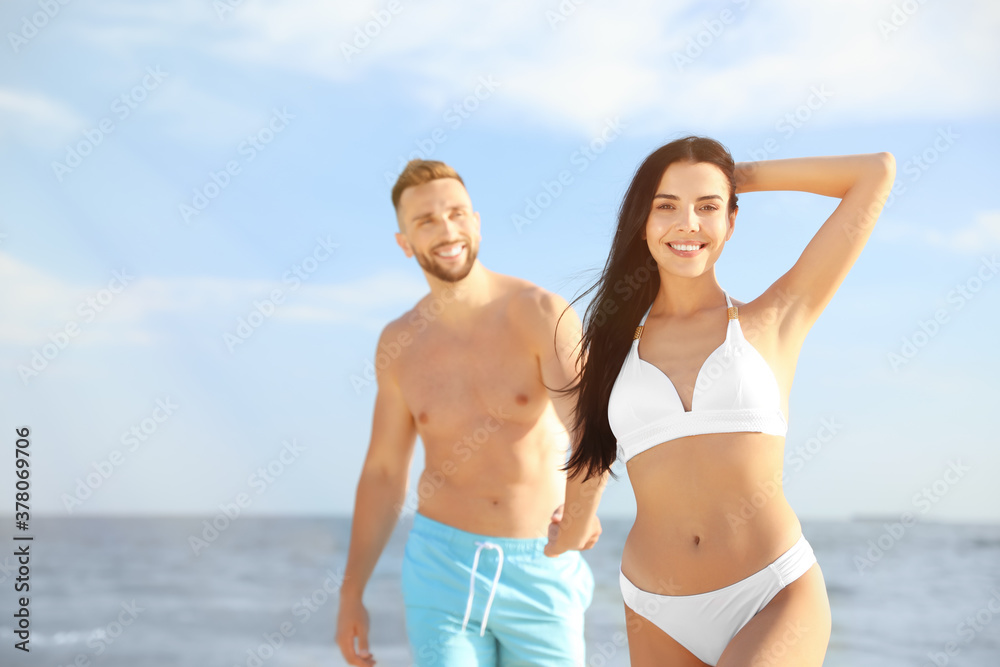 Happy young couple at beach on sunny day