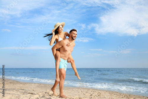 Canvas Print Happy young couple having fun on beach