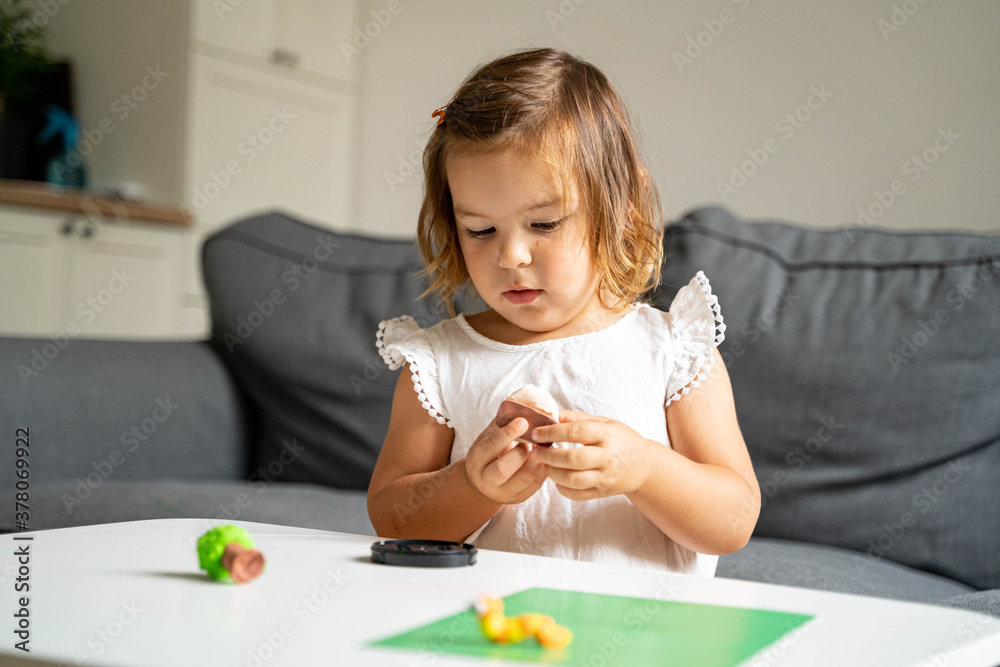 Caucasian toddler girl playing modeling play dough at home with mother. Homeschooling concept Caucasian toddler girl playing modeling play dough at home with mother. Homeschooling concept