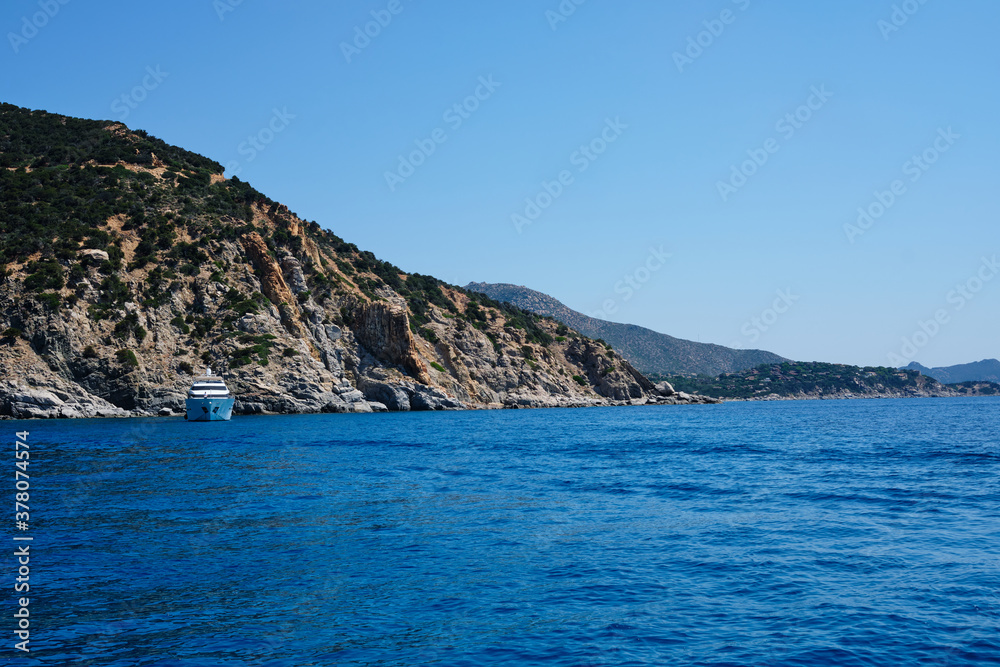 yacht anchored in a beautiful bay in the south coast of Sardinia on a sunny day.