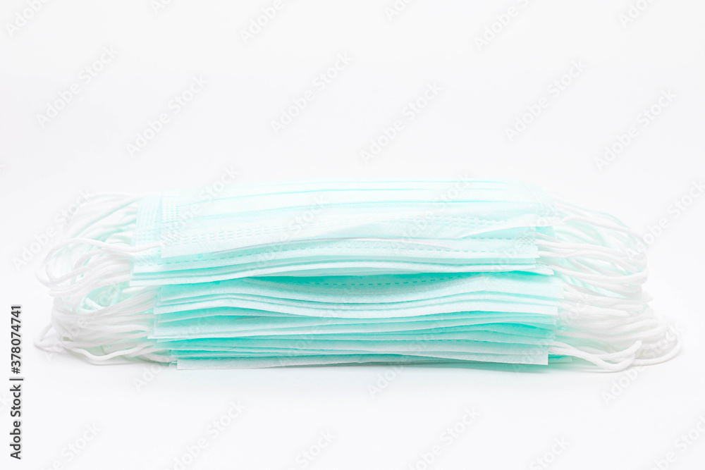 A stack of medical face masks on a white background. Article about the second wave of coronavirus. Protection of the respiratory system. Pneumonia and coronavirus. Copy space A stack of medical face masks on a white background. Article about the second wave of coronavirus. Protection of the respiratory system. Pneumonia and coronavirus. Copy space