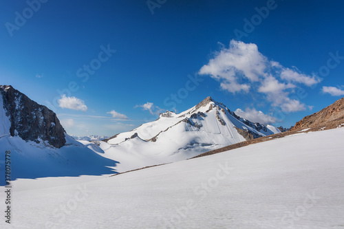 Mountain landscape view in Kyrgyzstan. Rocks, snow and stones in mountain valley view. Mountain panorama.