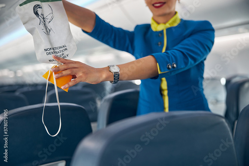 Air hostess showing where to getting an oxygen mask on board