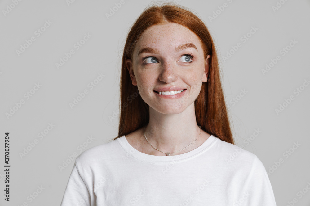 Image of happy ginger girl smiling and looking aside