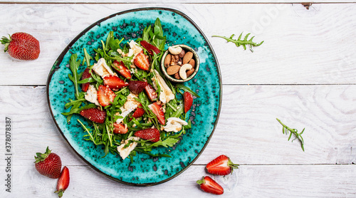 salad with arugula, strawberries and cheese brie, camembert. Healthy food diet food concept. recipe background
