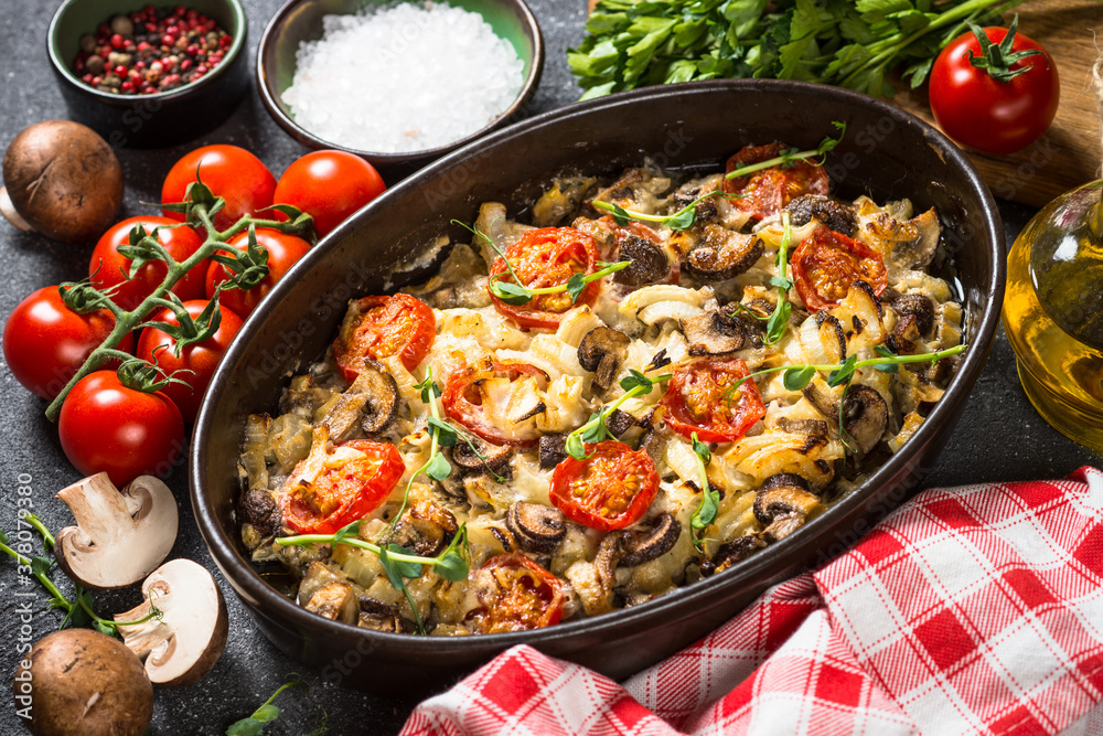 Baked meat with vegetables on black table. Baked meat with vegetables on black table.