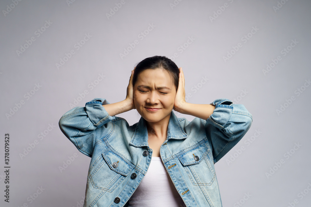 Asian woman bored and annoyed, covering her ears isolated over white background. Asian woman bored and annoyed, covering her ears isolated over white background.
