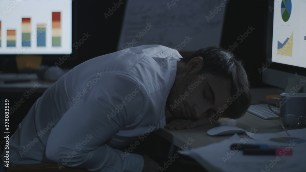 Tired business man sleeping on desk front computer screen in night office. Tired business man sleeping on desk front computer screen in night office.