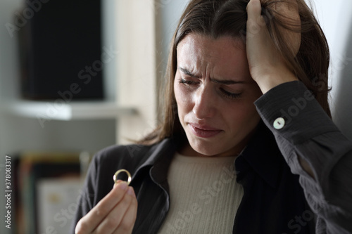 Sad wife complaining looking at ring in the night photo