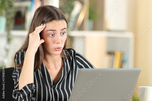 Canvas Print Worried woman discovering error on laptop
