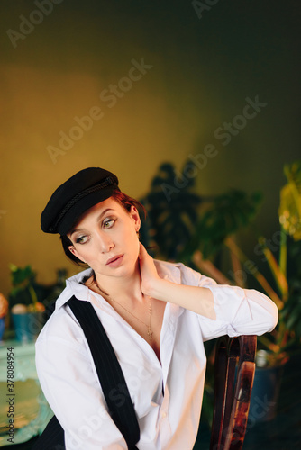 Portrait of a beautiful young woman in a white shirt and black pants in the Studio