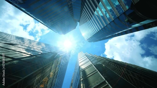 Low angle view of city skyline buildings, blue sky and glass mirrored facades.	