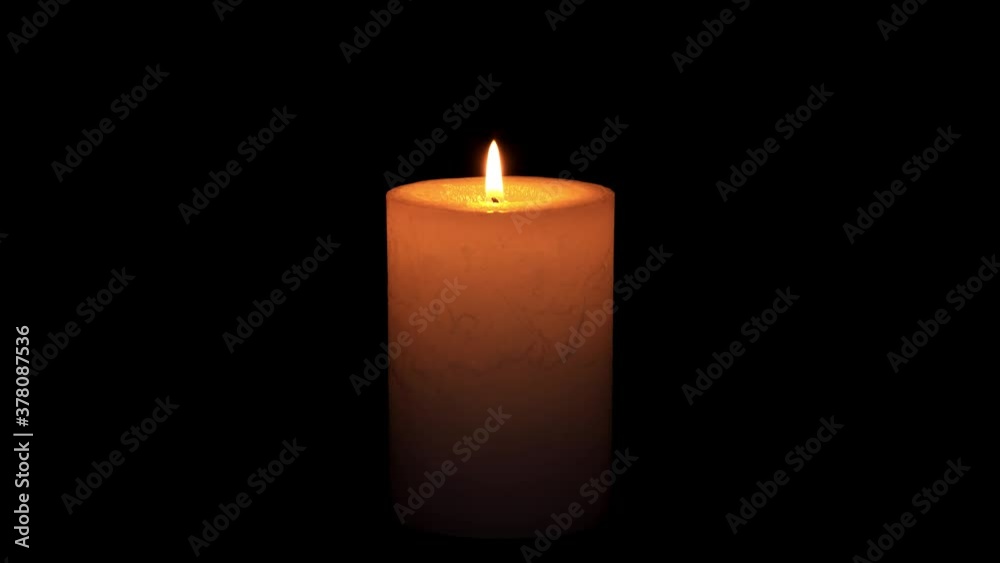 A single white candle burning.Isolated candle burning with dark background.White paraffin candle with yellow shades burns on a black background.Background or illustration of remembrance or celebration A single white candle burning.Isolated candle burning with dark background.White paraffin candle with yellow shades burns on a black background.Background or illustration of remembrance or celebration