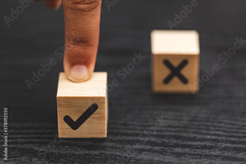 hand choose yes, true and blurred NO, false symbols on wood cube
