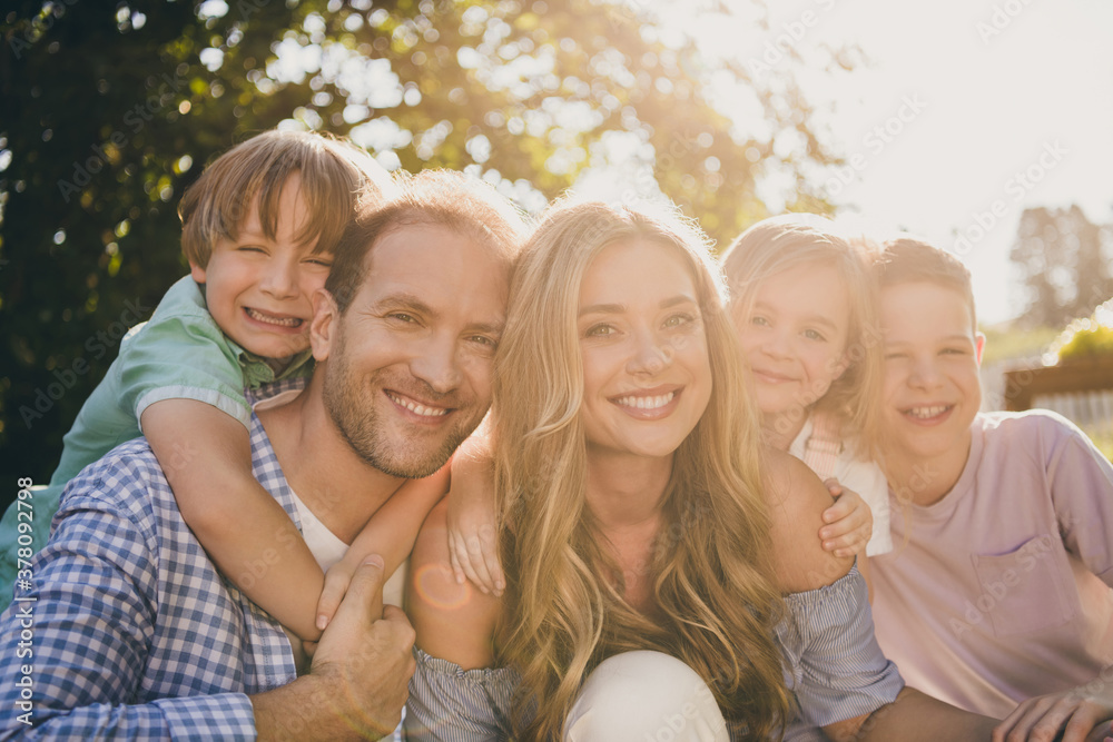 Dream summer weekend countryside backyard relax concept. Mom dad and their little kids girls boys hug embrace enjoy sunset evening park garden day outdoors Dream summer weekend countryside backyard relax concept. Mom dad and their little kids girls boys hug embrace enjoy sunset evening park garden day outdoors