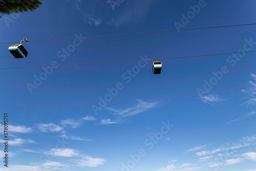 4k footage of the touristic cable car flying over the Tagus riverside in the city of Lisbon at sunset. Blue sky background with scattered clouds. Travel touristic concept lifestyle.