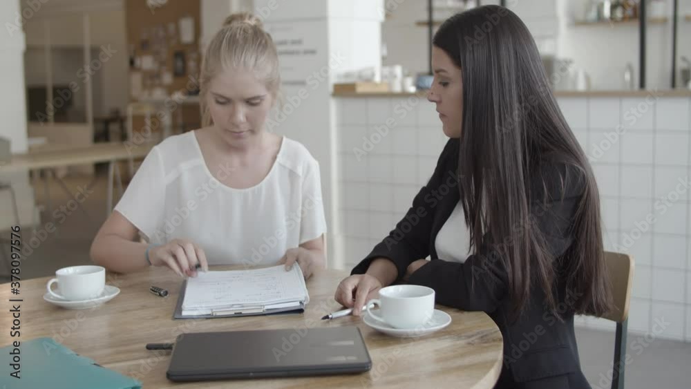 Young female client meeting with insurance agent, signing agreement, shaking hands and smiling. Medium shot. Contract or deal concept Young female client meeting with insurance agent, signing agreement, shaking hands and smiling. Medium shot. Contract or deal concept