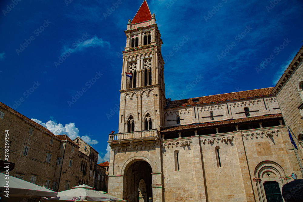 Obraz premium Fachada de iglesia con torre de corte románico y gótico en plaza