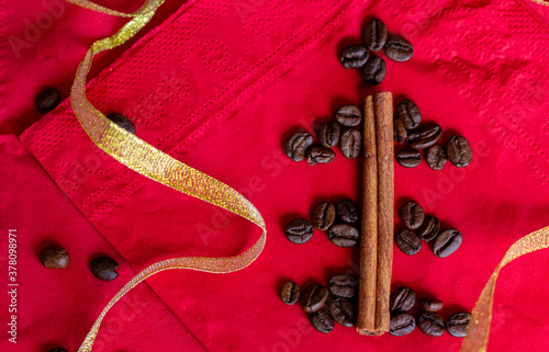 Red and gold Christmas background with coffee and cinnamon sticks new year lovely drink and food