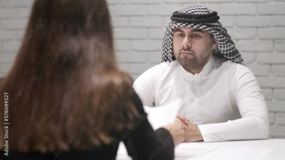 Arab businessman at a meeting with a partner before signing important documents. Business woman hands over a cooperation agreement. Arab businessman at a meeting with a partner before signing important documents. Business woman hands over a cooperation agreement.