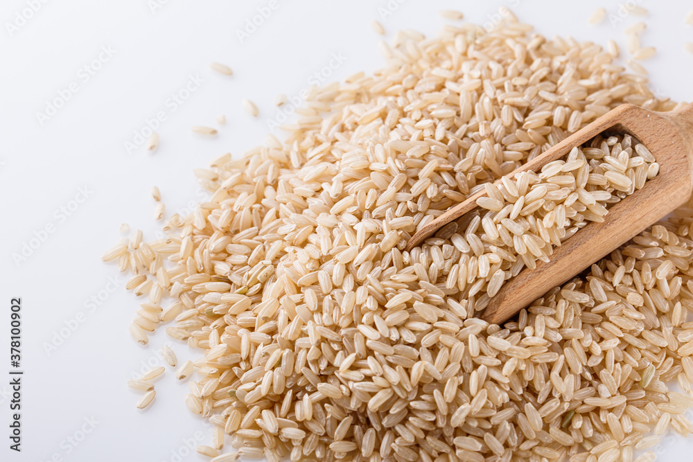 raw brown rice on white acrylic background raw brown rice on white acrylic background